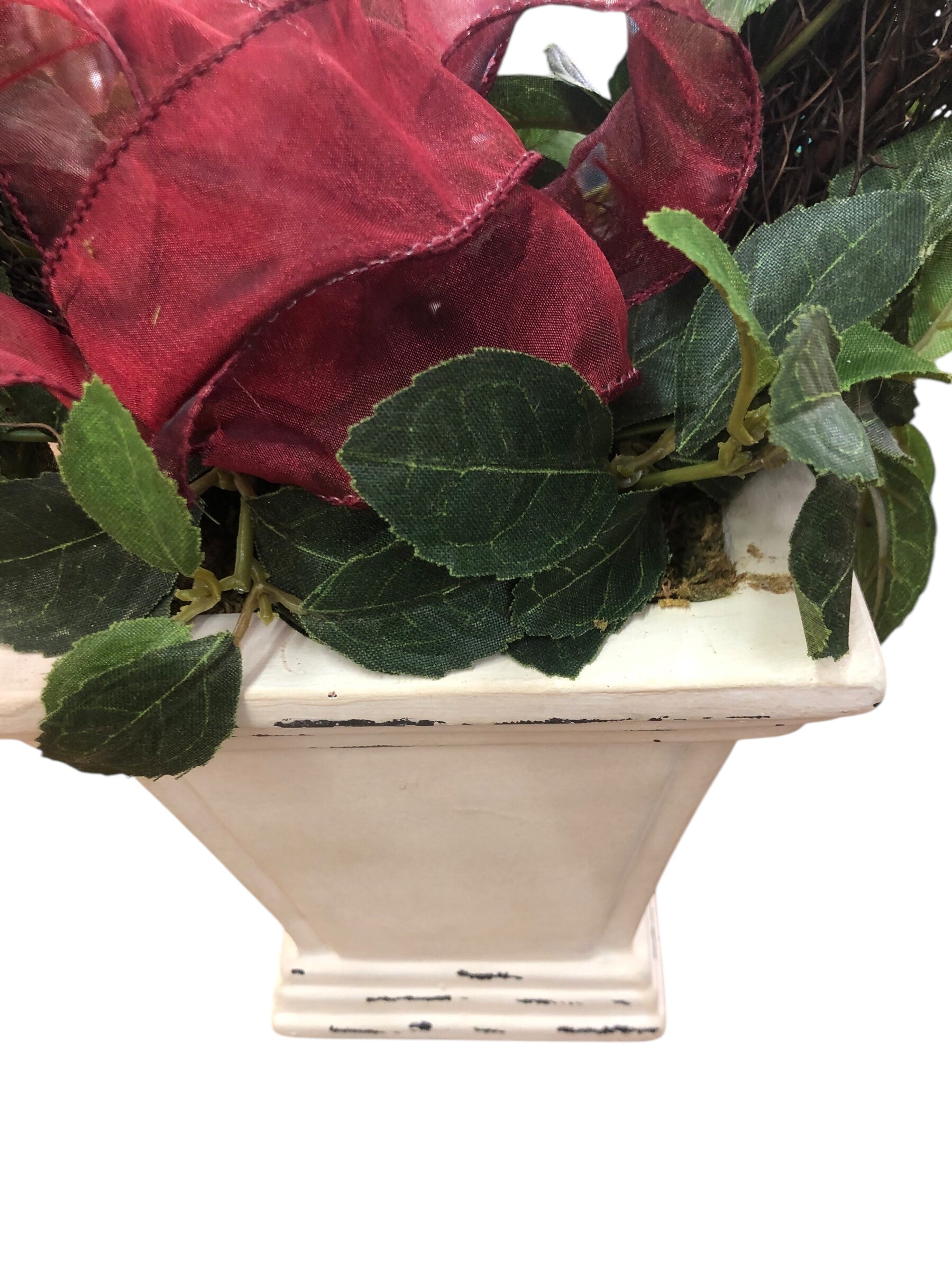 Wreath in white pot/green leaves/red berries