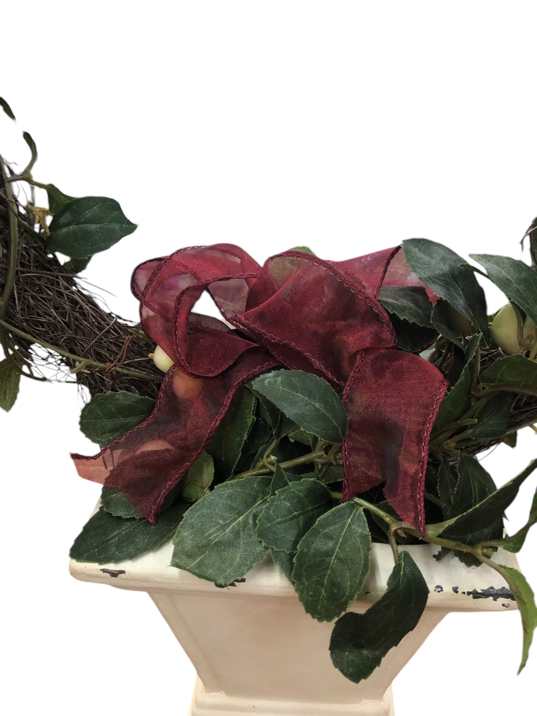 Wreath in white pot/green leaves/cream berries