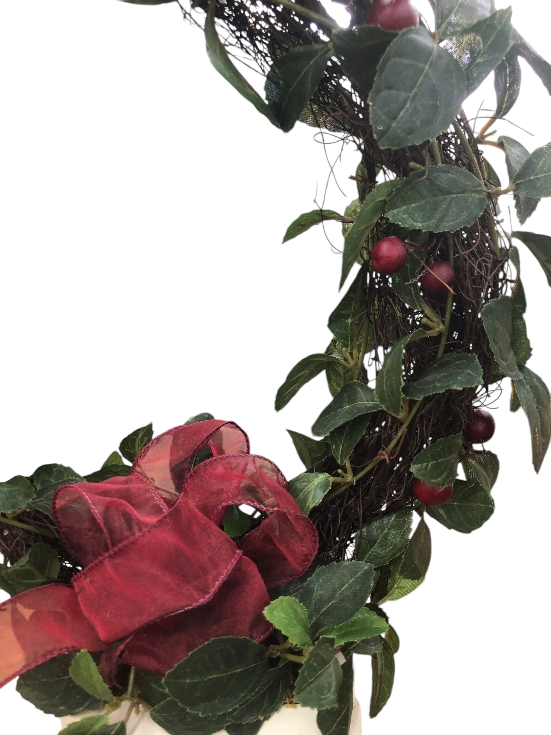 Wreath in white pot/green leaves/red berries