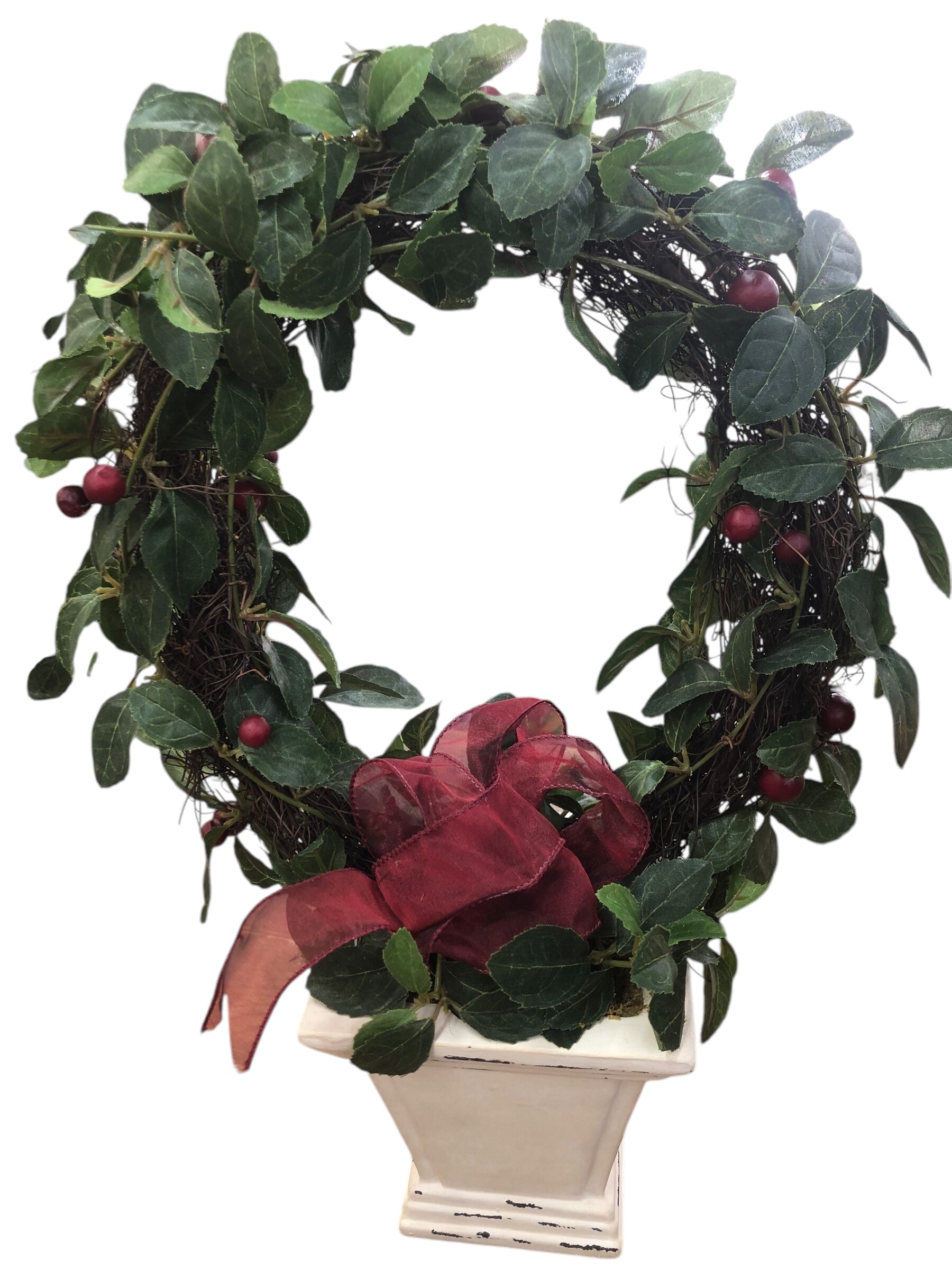 Wreath in white pot/green leaves/red berries