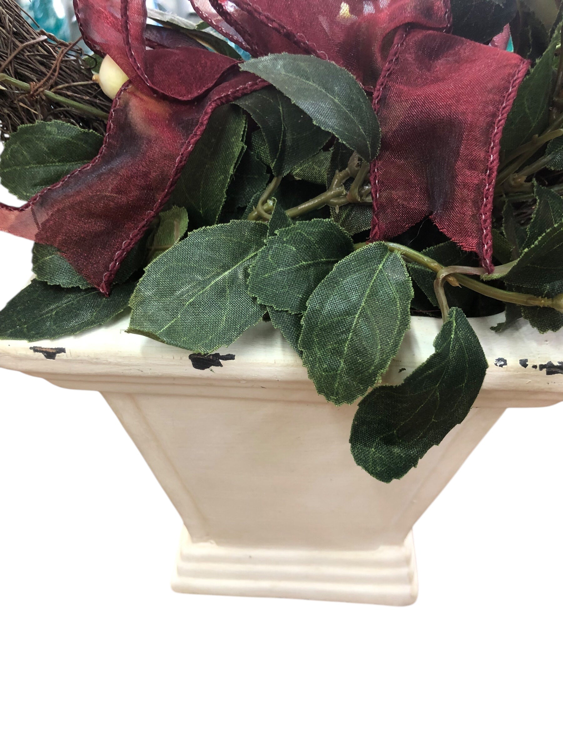 Wreath in white pot/green leaves/cream berries